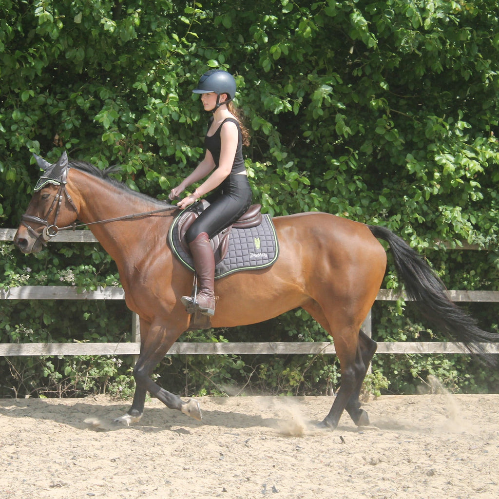 A young woman riding a horse wearing a black crop top