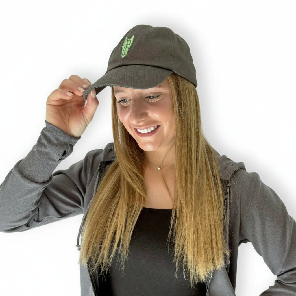 A woman wears a stylish grey Dad cap with a silver grey equestrian logo on it