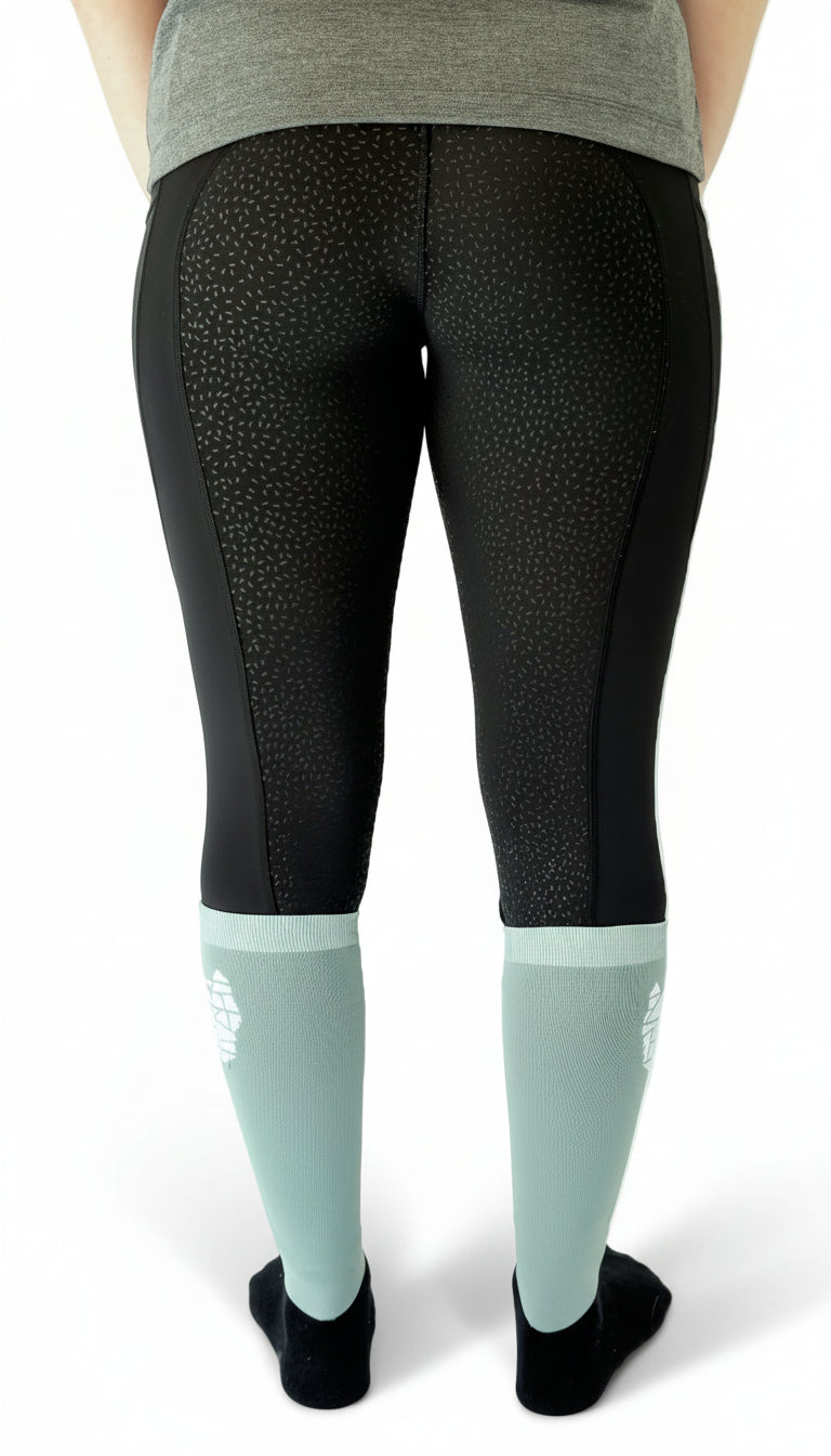 Rear view of a woman wearing black equestrian riding leggings with a full gel seat and double pockets